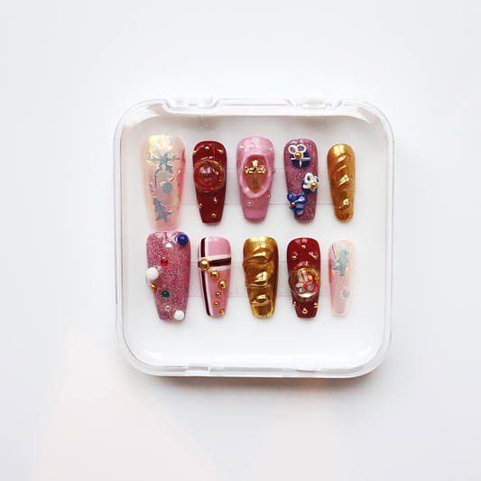 Set of decorated false nails in a clear plastic case on a white background